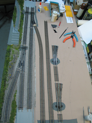 The Fabrication & Machining module. The switches on the right are for tracks that will run into mill buildings. The line along the left has been cut back, and the diverging route converted to a rail-trail.