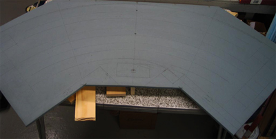The plan is transferred from the plan drawn on paper to the homosote top layer of the module. Homosote is used because it holds the spikes and track nails well, can be easily cut, and holds its shape well when sealed with paint or glue. Most modules have Homosote only where the tracks run, to reduce weight, with the rest of the module surface made of extruded styrofoam insulation board. Make sure to seal the top, bottom, and edges of the Homasote with either latex paint or white glue, to prevent changes in humidity from causing problems with your roadbed and track.