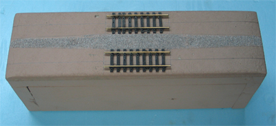 Our one-foot-long module can be used to fill in the odd gap in the display when needed. At other times, it is handy for showing people the basic parts of a standard module. For example, the tracks start four and a half inches from each end of the module, which allows us to use nine-inch snap-track sections to bridge the gaps between modules.